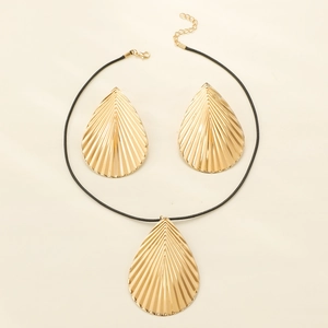 Gold leaf-textured teardrop jewelry set with necklace and earrings on beige background