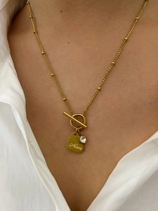 Detail of gold OT buckle necklace with crystal heart pendant engraved with Mom text
