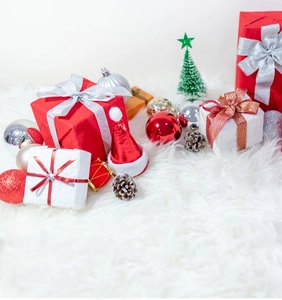 Festive collection of Christmas gift boxes and ornaments on a white plush surface