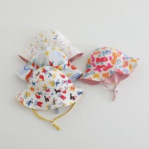 Detailed view of kids reversible sun hats with colorful graffiti prints and drawstrings