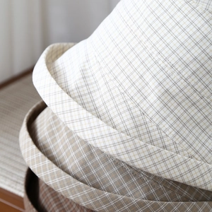 Detailed close-up of checkered cotton-linen bucket hat with rolled brim and fine stitching