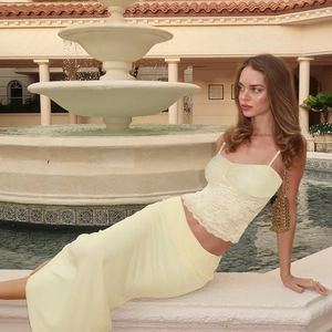 Lace tube top and satin maxi skirt set in pale yellow shown on a model by a fountain