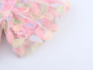 Macro detail of sweet floral mesh blouse featuring 3D sequins and colorful petal embroidery