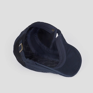 Detail of navy cotton flat cap showing quilted lining and vintage metal buckle strap