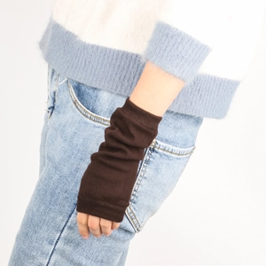 Close-up of dark brown knitted arm warmers with ribbed cuffs and textured soft knit fabric