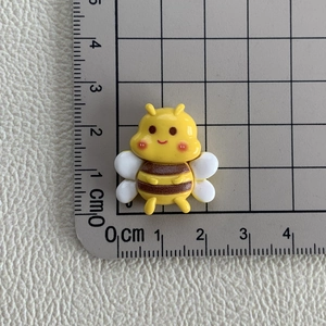 Vue macro montrant les dimensions d'une breloque abeille en résine pour le bricolage