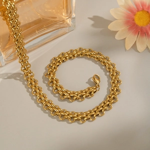 Detailed view of golden double-link chain necklace with metallic luster on gray background