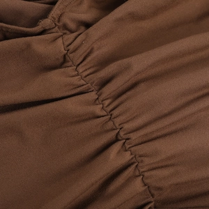 Gros plan sur un tissu en maille marron foncé montrant les coutures et la texture plissée
