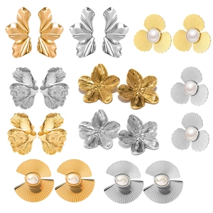 Macro view of assorted gold and silver petal-shaped earrings with pearl accents