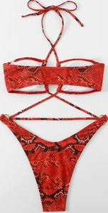 Flat lay of red and black snake print bikini with gold rings and halter tie details