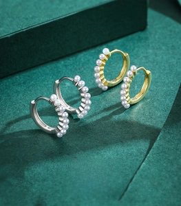 Detailed macro view of 925 sterling silver hoop earrings with a row of inlaid pearls