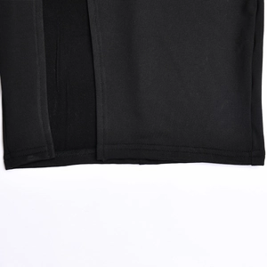 Detailansicht des schwarzen Strickkleid-Saums mit feinen Nähten und seitlichem Schlitz
