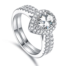 Macro shot of a sparkling pear-cut stone bridal ring set with shimmering pavé band