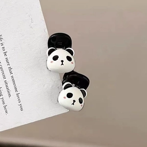 Close-up of adorable black and white panda hair clips on a decorative card