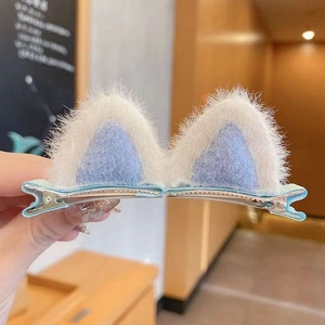 Detailed view of plush cat ear hair clips in light blue and white for girls