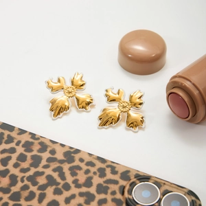 Detailed macro view of 18K gold plated flower earrings with white enamel coating