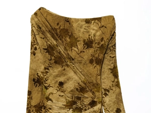 Détail de la robe en velours avec imprimé floral doré et plis texturés élégants