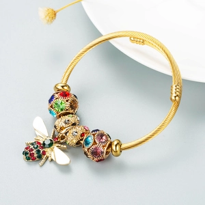 Golden twisted bangle featuring a sparkling bee pendant and colorful crystal charms