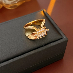Macro shot of gold floral ring with cubic zirconia on black jewelry box background