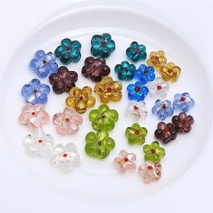 Close-up of assorted colorful glass flower beads for DIY jewelry making on white plate