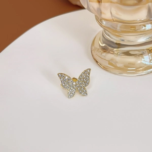 Gros plan sur boucle d'oreille papillon dorée avec pierres de zircone blanches étincelantes