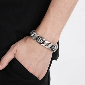 Détail du bracelet chaîne en acier titane argenté vintage avec emblème de croix au poignet