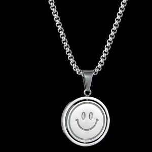 Macro detail of a rotating smiley face pendant on a polished silver stainless steel box chain