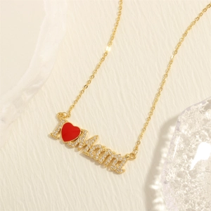 Macro shot of 18K gold-plated Mama pendant with red heart enamel and micro-pave stones