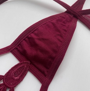 Close-up of wine red lace embroidery and knitted fabric details on the thong underwear