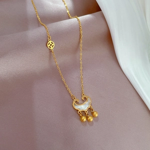 Detail of gold Ruyee lock pendant with white shell inlay and small golden bells on silk