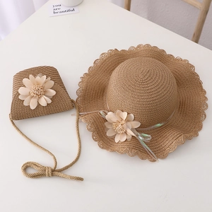Detail of khaki straw hat and matching bag with wave edges and floral accents