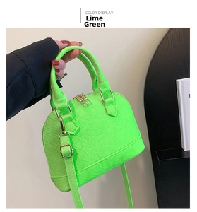 Detail of grass green shell bag with embossed texture and gold metal zipper and hardware