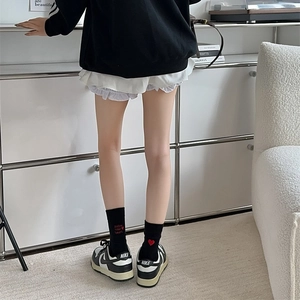 Detail of black cotton socks featuring red heart embroidery and follow your heart text