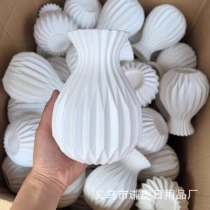 Detailed close-up of white geometric pleated plastic vase showing matte vertical texture