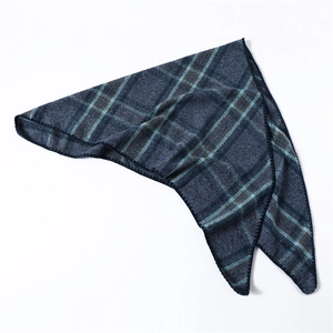 Close-up of soft blue green and brown plaid scarf with thick woven texture and hemmed edges