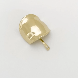 Macro shot of minimalist gold alloy hair hook with smooth metallic finish and elegant curve