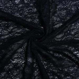 Close-up of intricate black lace fabric with delicate floral hollow-out patterns