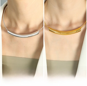 Detailed comparison of gold and silver curved tube necklaces on a minimalist model