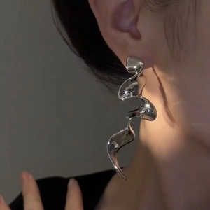 Detailed close-up of silver long liquid ribbon tassel earrings with metallic finish