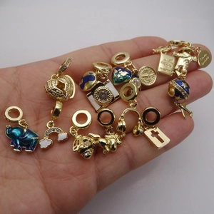 Collection of gold enamel charms featuring heart, elephant, and globe designs