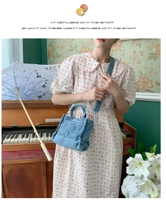 Detailed view of light blue denim tote bag with front pocket and adjustable strap