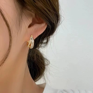 Close-up of double-layered gold hoop earrings featuring sparkling cubic zirconia stones