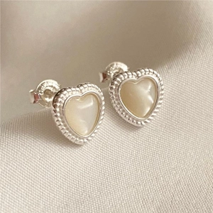 Macro shot of S925 sterling silver heart earrings with white shell inlay and beaded edges