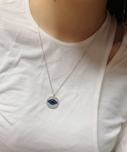 Macro view of S925 sterling silver evil eye pendant with blue and white zircon stones