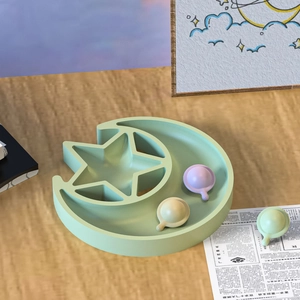 Detail view of light green moon and star silicone storage tray with small accessories