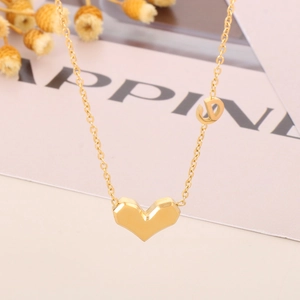 Détail du collier avec pendentif cœur 3D doré et breloque lettre sur chaîne élégante