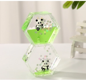Macro detail of hexagonal liquid timer toy with green oil drops and panda figures