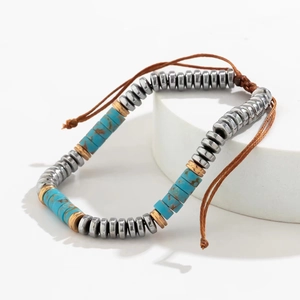 Detailed view of handmade hematite and turquoise beaded bracelet on brown woven cord