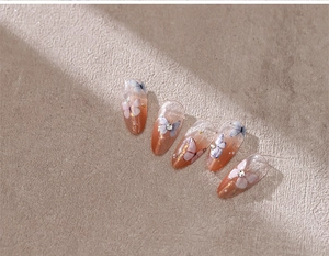 Detail of almond-shaped butterfly nail stickers with rhinestones and beauty lettering