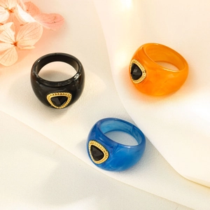 Detailed view of colorful square resin rings with gold metal inlay and triangle gemstones